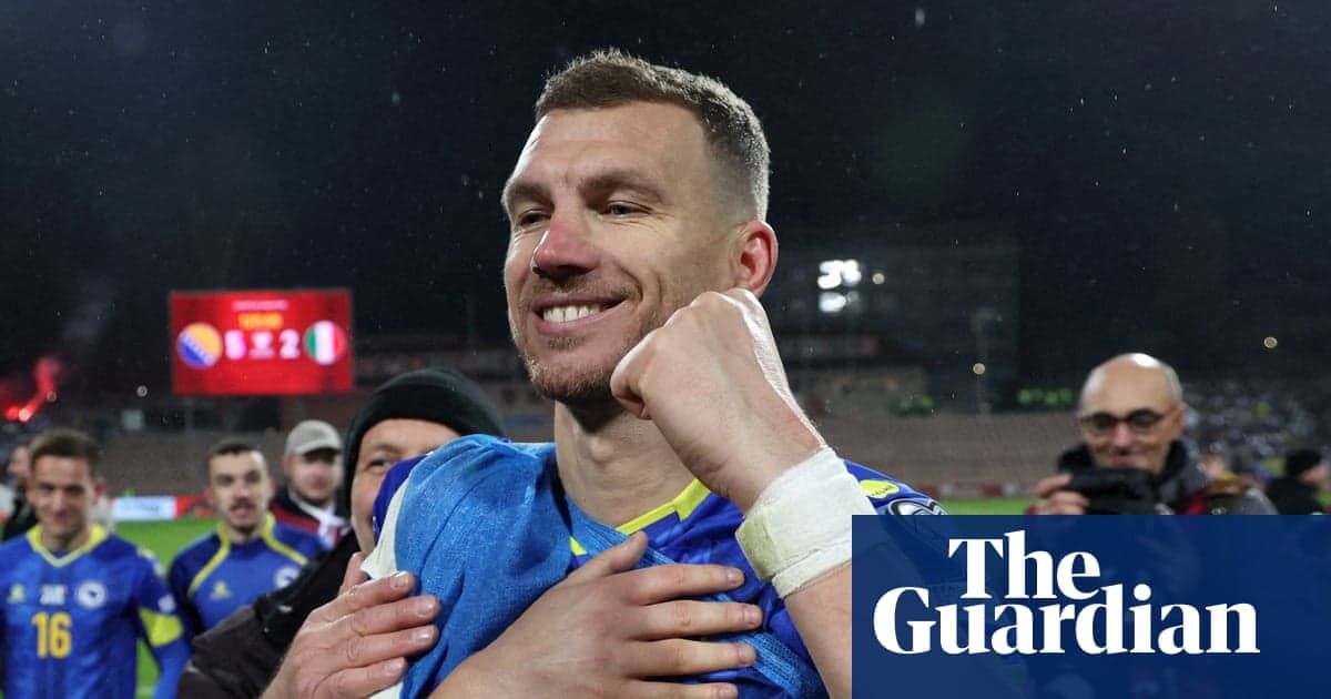 Edin Dzeko celebrating with arms outstretched after Bosnia and Herzegovina qualified for the World Cup, with the team's blue and white colors in the background.