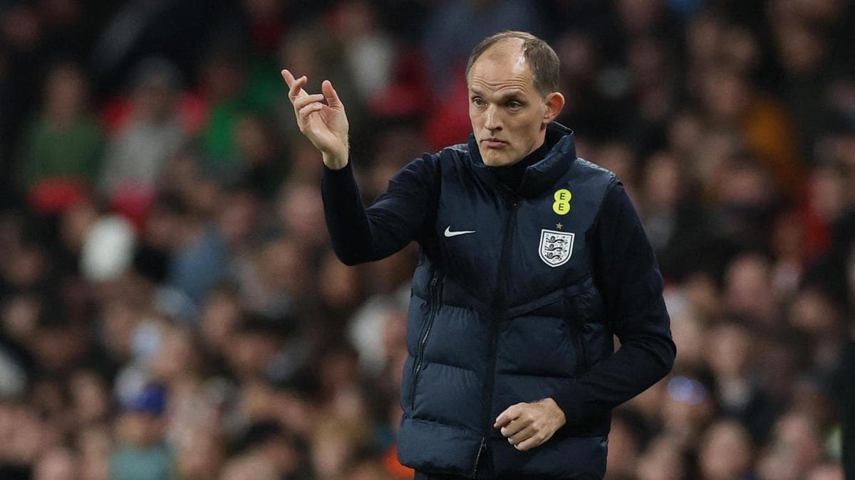 Thomas Tuchel speaking at a press conference, with the England squad graphic behind him